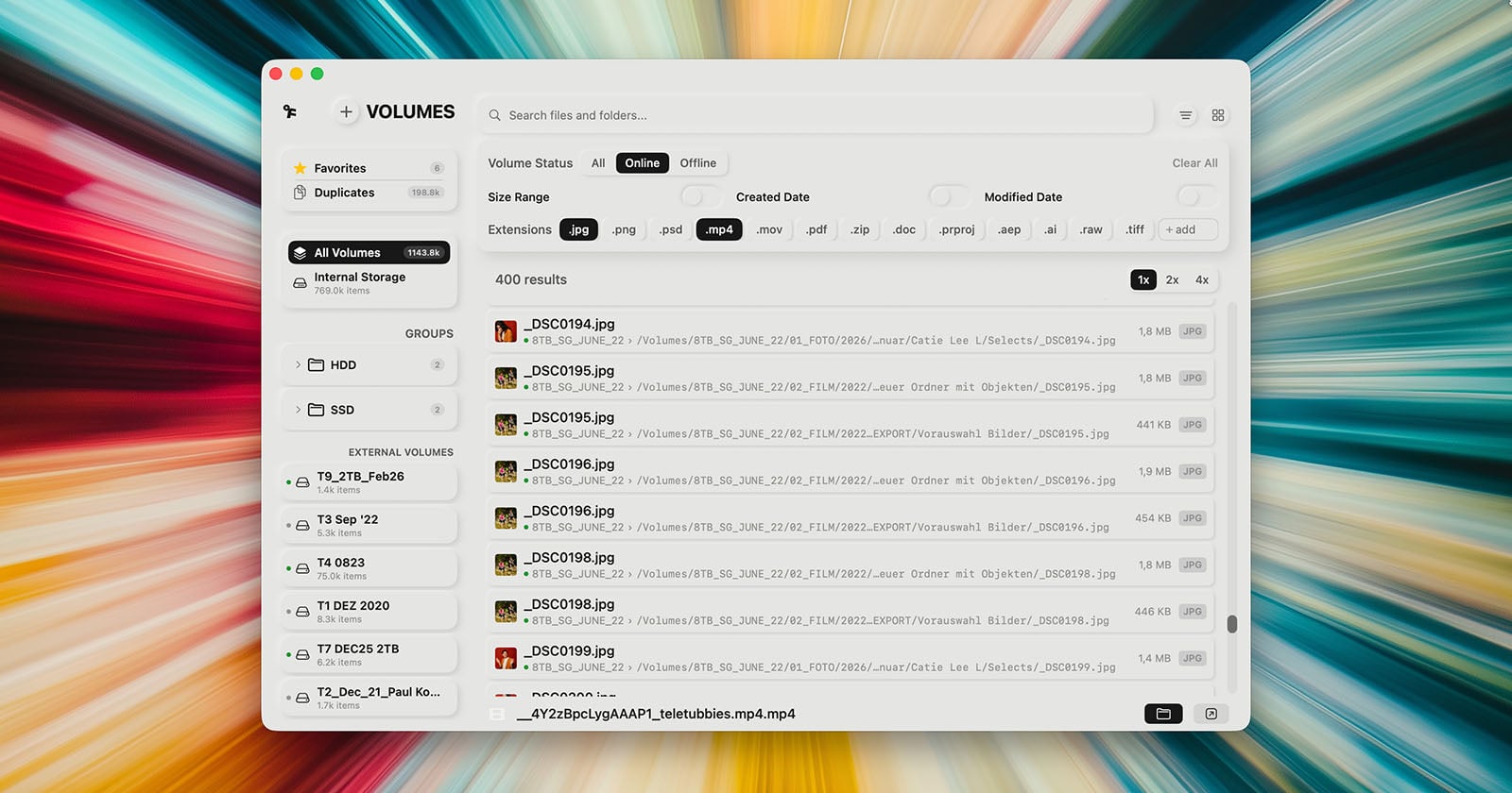 A computer screen displays a file management application with a list of image and video files, organized by volume. The background features colorful, blurred light streaks radiating outward.