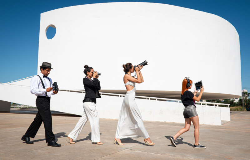 Four photographers walking across concrete