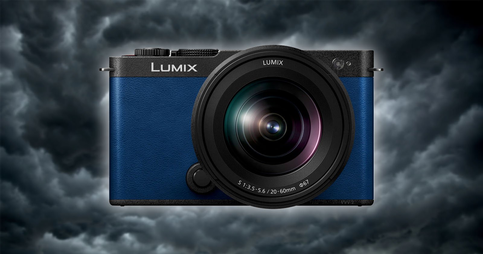 A blue Lumix camera is centered against a backdrop of dark, stormy clouds. The camera lens is prominently displayed, and the brand name Lumix is clearly visible above the lens. The overall mood is dramatic, highlighting the camera's sleek design.
