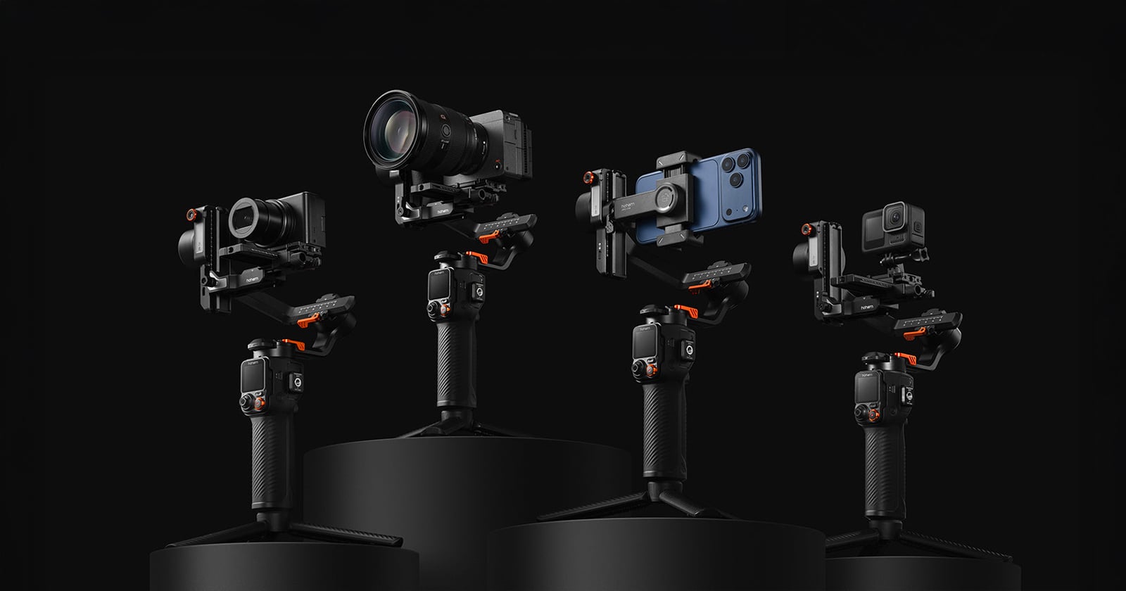 Four camera stabilizers, each holding a different device: a DSLR camera, a mirrorless camera, a smartphone, and an action camera, are displayed on black podiums against a dark background.