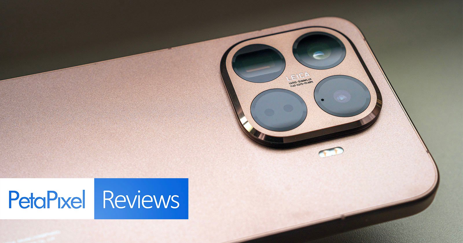 A close-up view of the rear camera module on a gold-colored smartphone, featuring multiple lenses and Leica branding. The bottom left corner displays the PetaPixel Reviews logo.