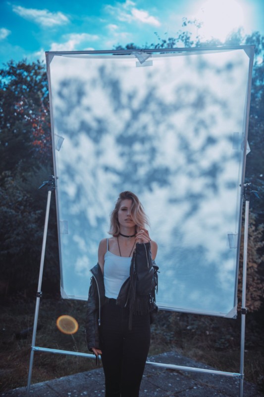 A woman posing against a do-it-yourself backdrop for dappled natural light