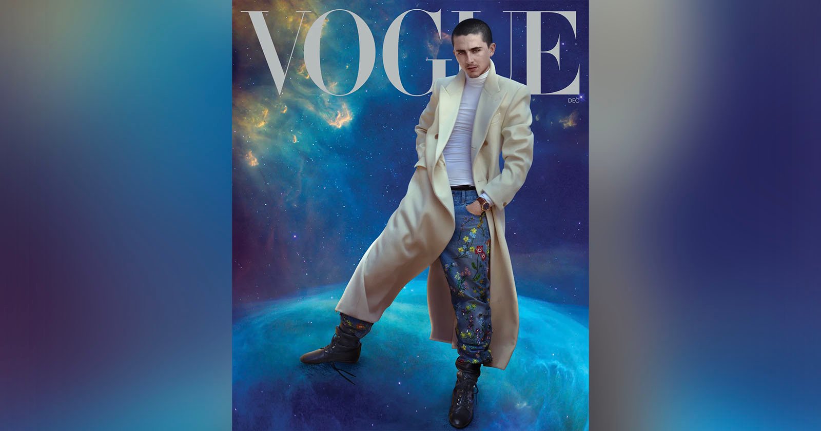 A person in a long beige coat, white turtleneck, and colorful pants poses confidently on a blue planet with a cosmic background. The word “VOGUE” appears at the top of the image.
