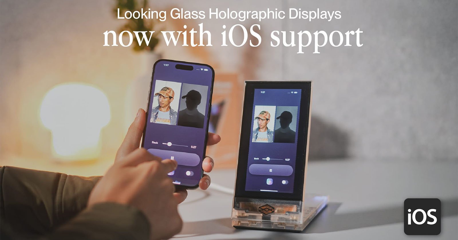 A person interacts with a smartphone and a tabletop holographic display. The devices show identical interfaces with photo editing controls. Text reads, Looking Glass Holographic Displays now with iOS support.