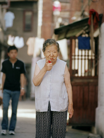 eightfish-80-year-old-chinese-woman-lights-up-a-cigarette-in-a-small-alleyway.jpg