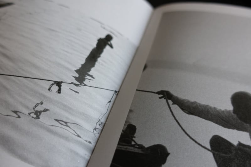 A photo book spread of a man holding a line over water