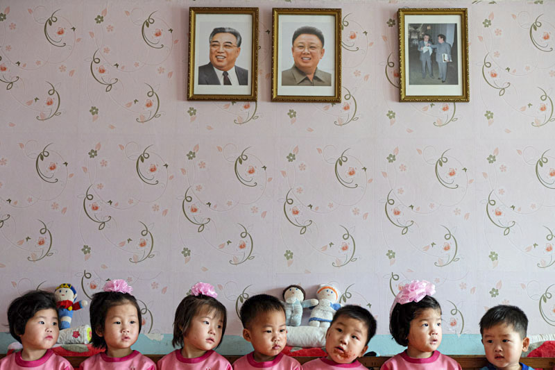 Children in Nampo orphanage are lined up beneath Kim Il-sung and Kim Jong-il portraits. © Fabian Muir/Courtesy Head On Photo festival