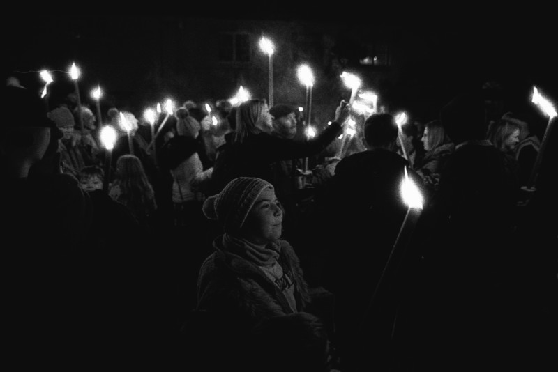 A crowd holding torches in a street A crowd holding torches in a street