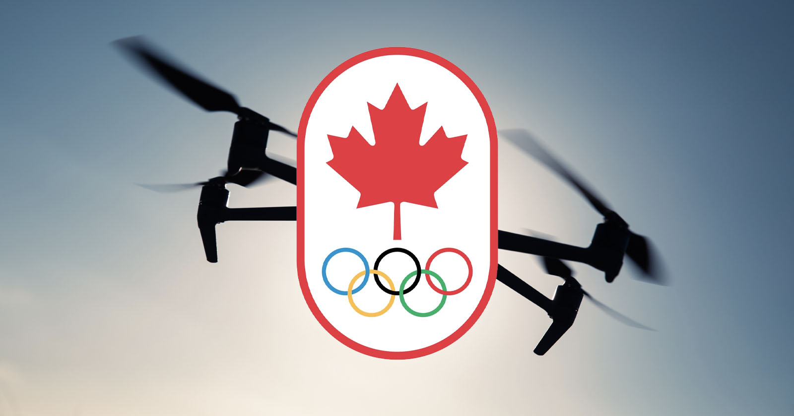 A drone in flight is silhouetted against a sky background. Superimposed over the drone is an emblem featuring a red maple leaf above the five interlocking Olympic rings, symbolizing the Canadian Olympic team. A drone in flight is silhouetted against a sky background. Superimposed over the drone is an emblem featuring a red maple leaf above the five interlocking Olympic rings, symbolizing the Canadian Olympic team.