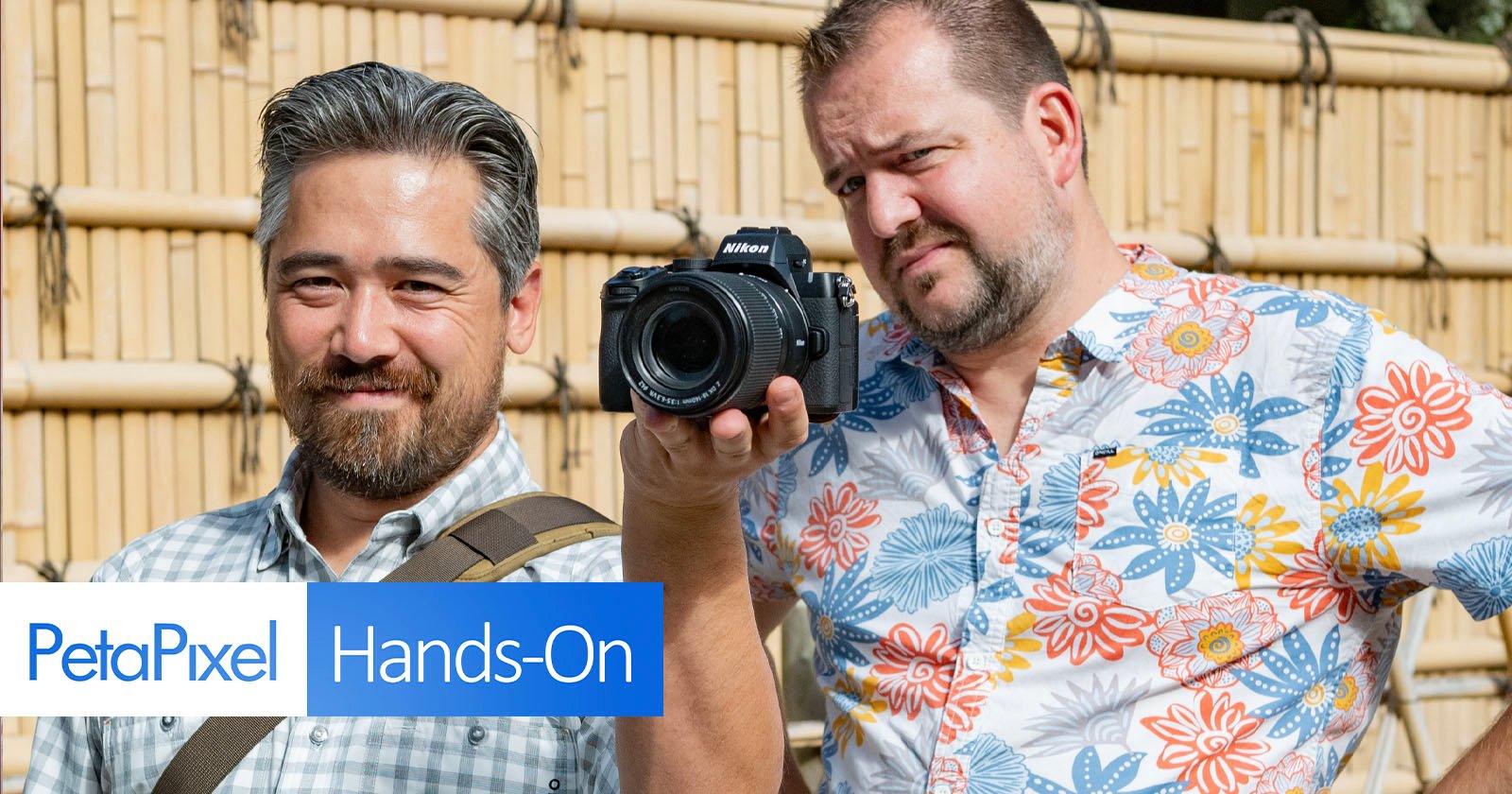 Two men are outdoors, both smiling. One holds a camera pointed towards the viewer. They stand in front of a bamboo fence, with a logo in the corner that reads PetaPixel Hands-On. Two men are outdoors, both smiling. One holds a camera pointed towards the viewer. They stand in front of a bamboo fence, with a logo in the corner that reads PetaPixel Hands-On.