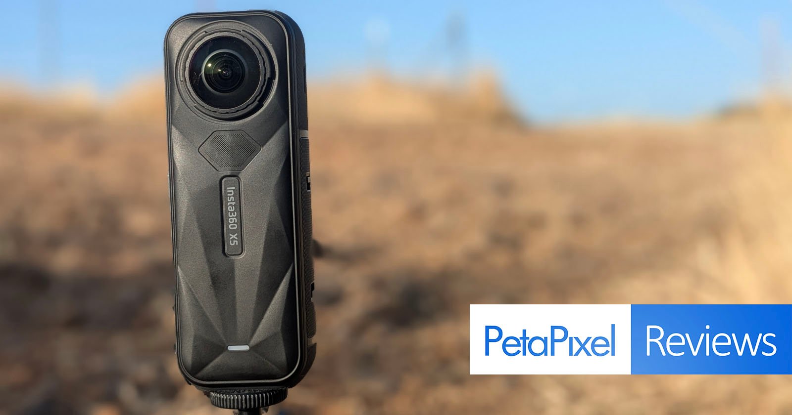 A close-up of the Insta360 One X2 camera is captured outdoors with a blurred, dry landscape in the background. The image features the Petapixel Reviews logo in the bottom right corner. A close-up of the Insta360 One X2 camera is captured outdoors with a blurred, dry landscape in the background. The image features the Petapixel Reviews logo in the bottom right corner.