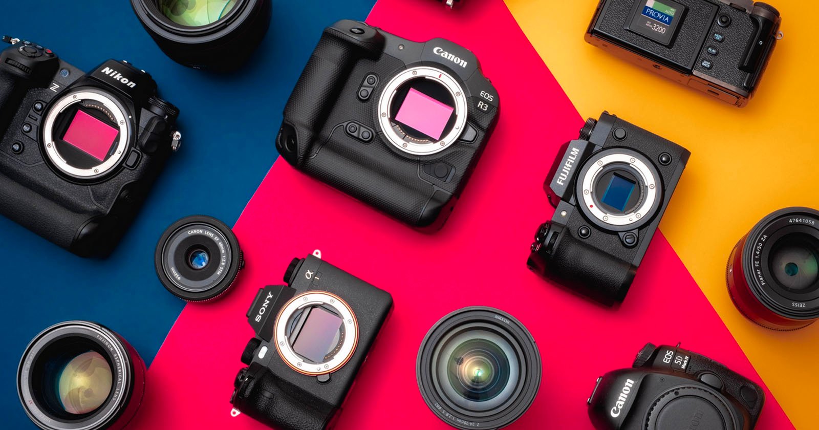 Various digital cameras and camera lenses from brands like Canon, Nikon, Sony, and Fujifilm are arranged on a colorful background with blue, red, and yellow sections. Various digital cameras and camera lenses from brands like Canon, Nikon, Sony, and Fujifilm are arranged on a colorful background with blue, red, and yellow sections.