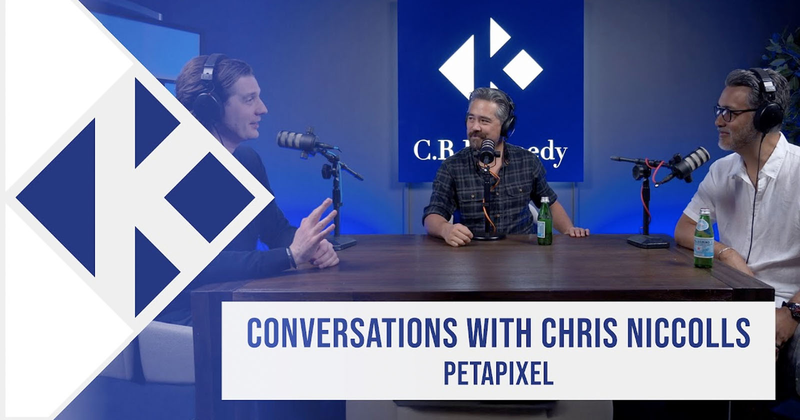 Three men sit at a podcast table with microphones, having a discussion. Behind them is a blue screen with the C.R. Kennedy logo. Text on screen reads “Conversations with Chris Niccolls, PetaPixel.”. Three men sit at a podcast table with microphones, having a discussion. Behind them is a blue screen with the C.R. Kennedy logo. Text on screen reads “Conversations with Chris Niccolls, PetaPixel.”.